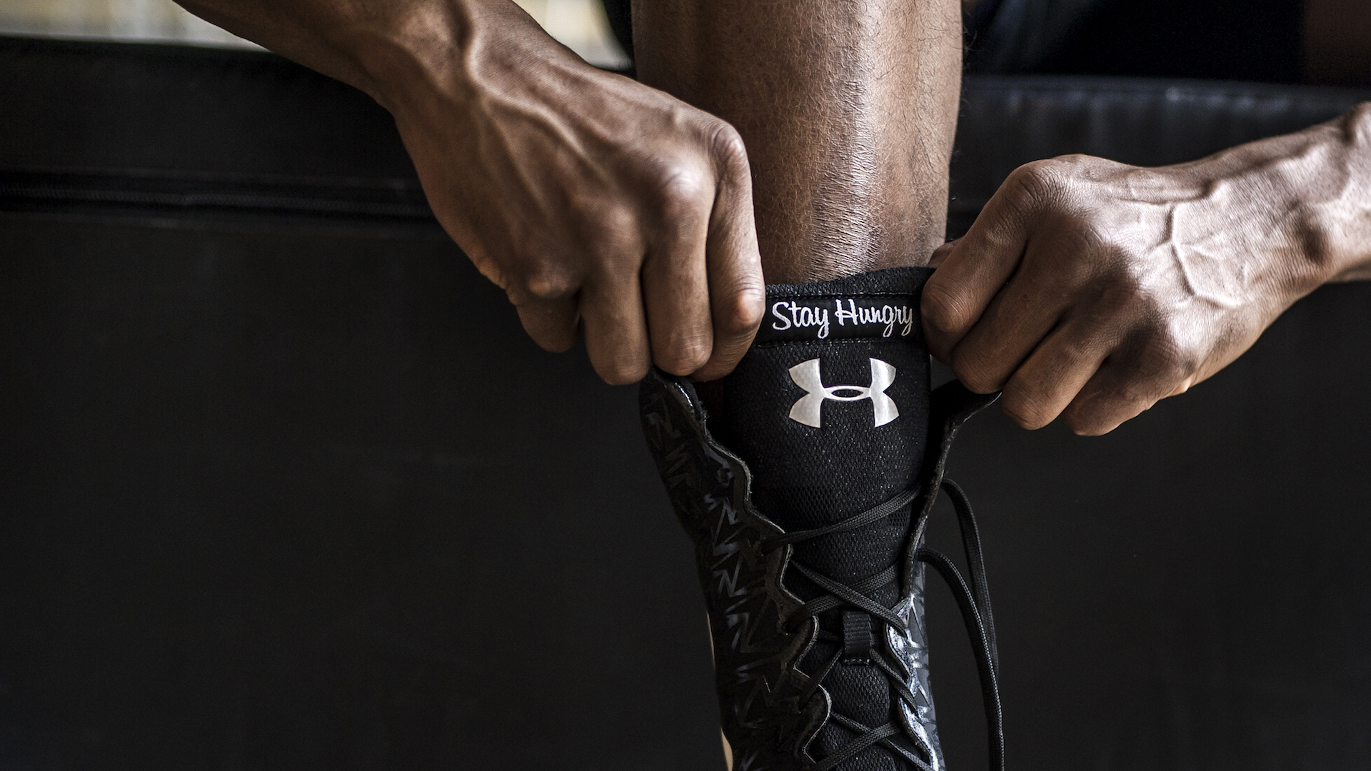 Anthony Joshua putting on his boots by sports photographer Stuart Manley